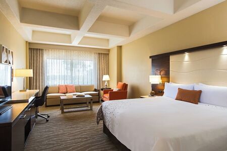 hotel room with king size bed. sofa bed, and desk